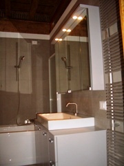 Bagno con raffinato accostamento di legno e gres fuocato